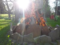 Feuerstelle mit Steinen umrandet und brennendem Holz, von Vinent Zigan, Garten- und Landschaftsbau aus Boppard
